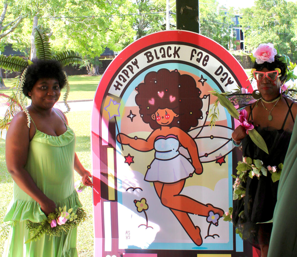 faebulous designer of the happy black fae day sign standing next to it with her mother.